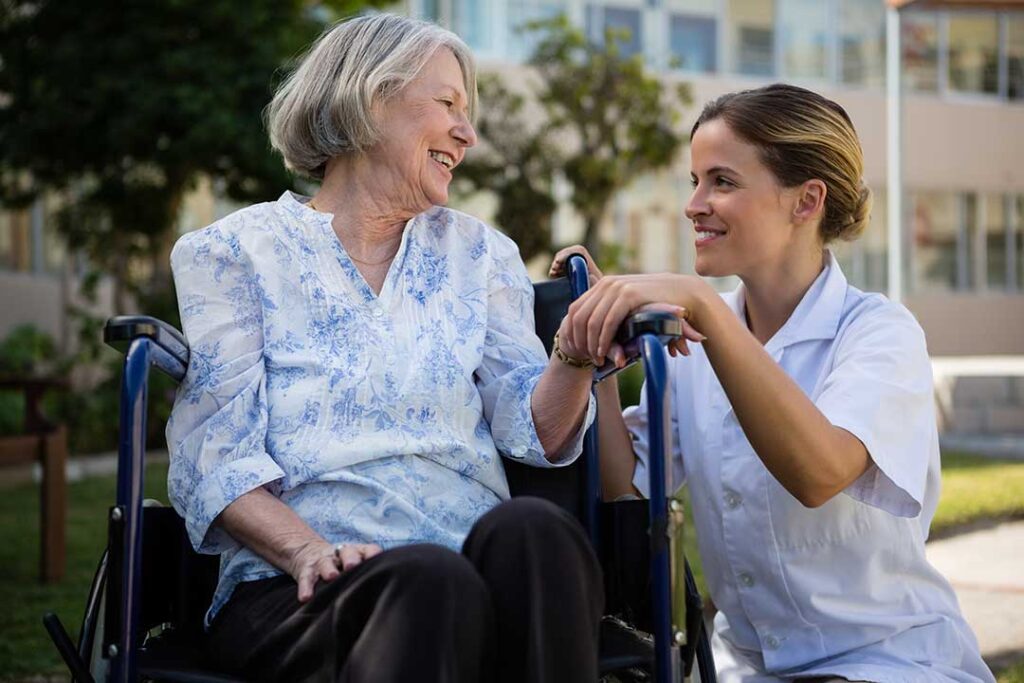 Older adult and family member review a daily care checklist at a kitchen table.