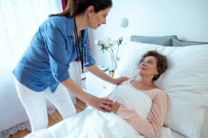 Older adult speaking with a caregiver in a bright assisted living apartment.